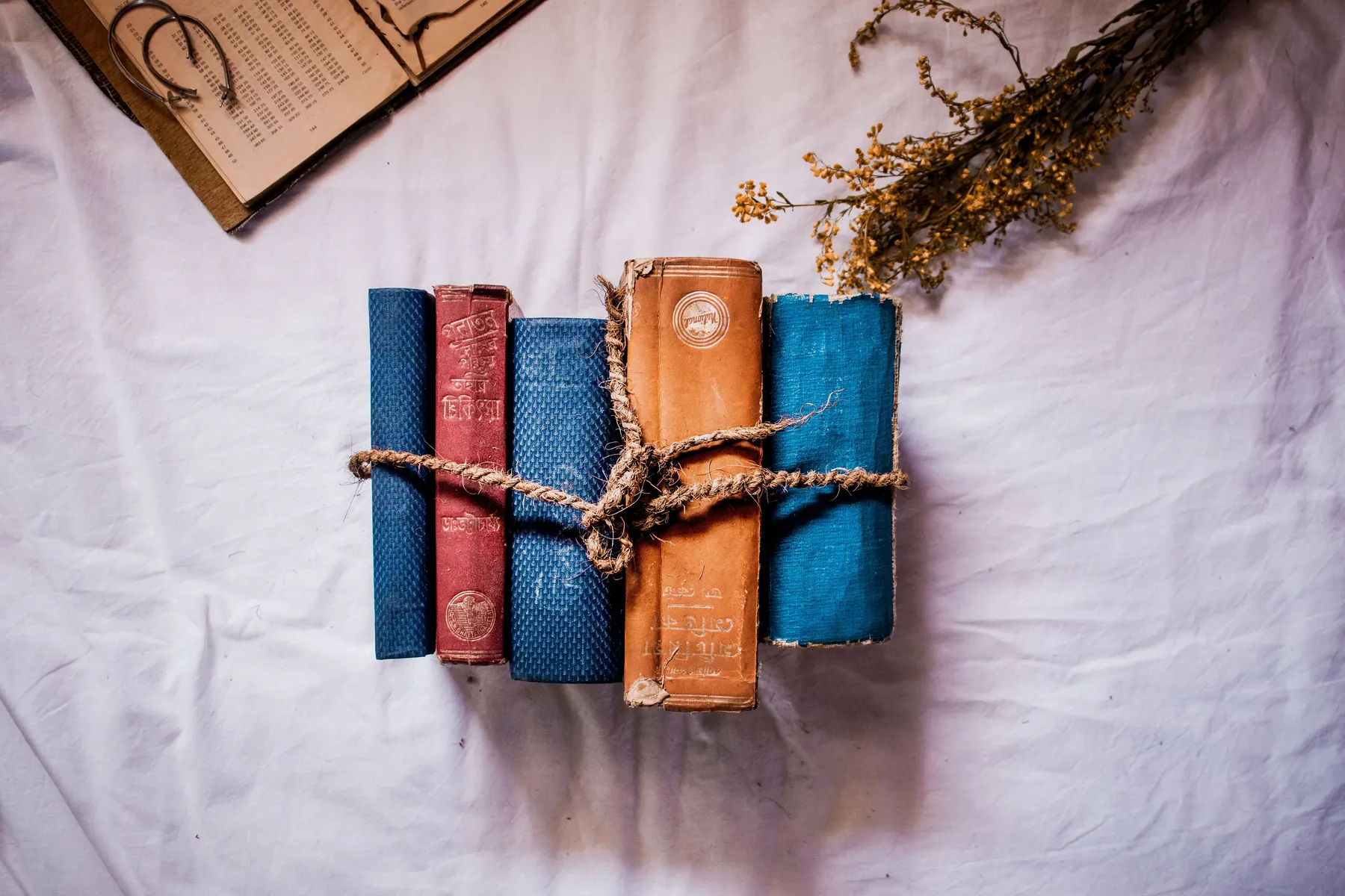 A collection of well-used books bound together with twine