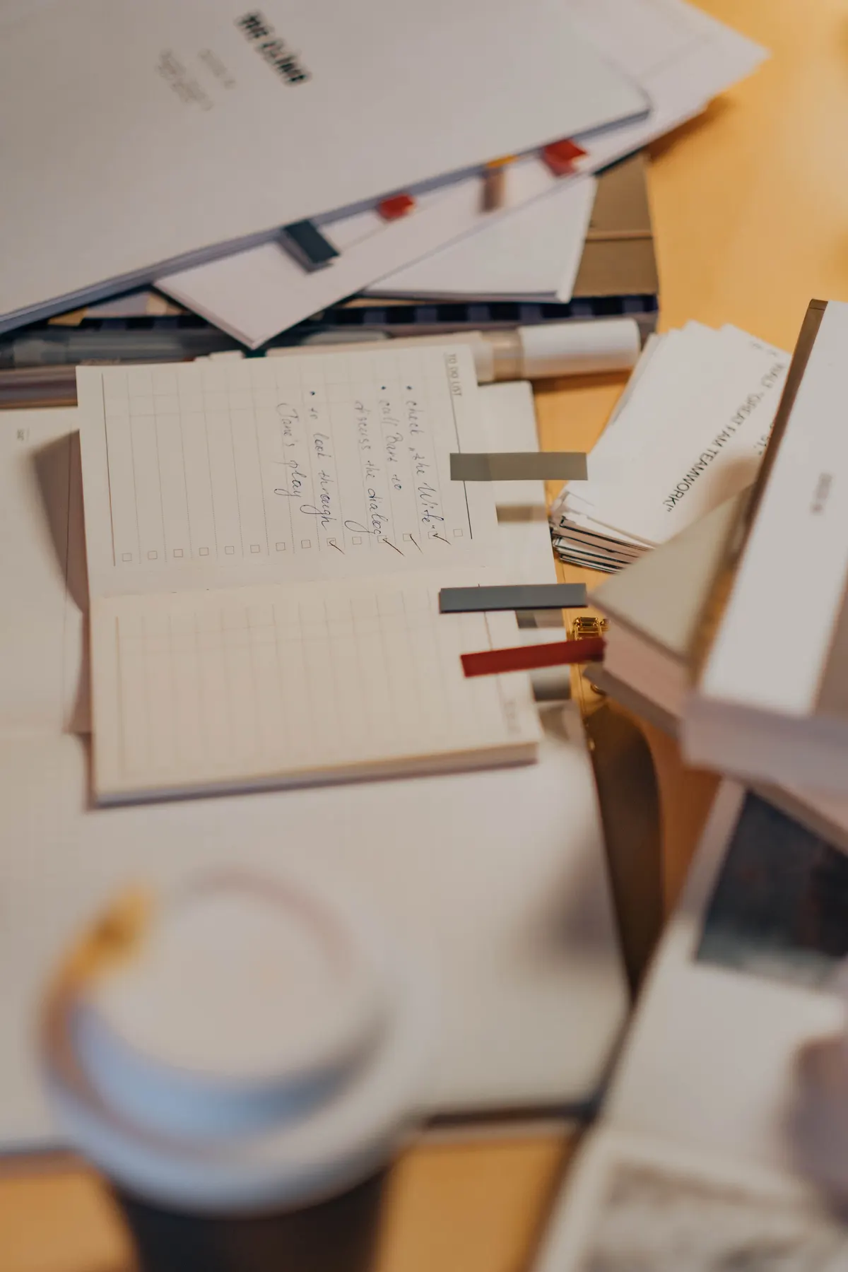 A working desk with handwritten notes, reference cards and pens
