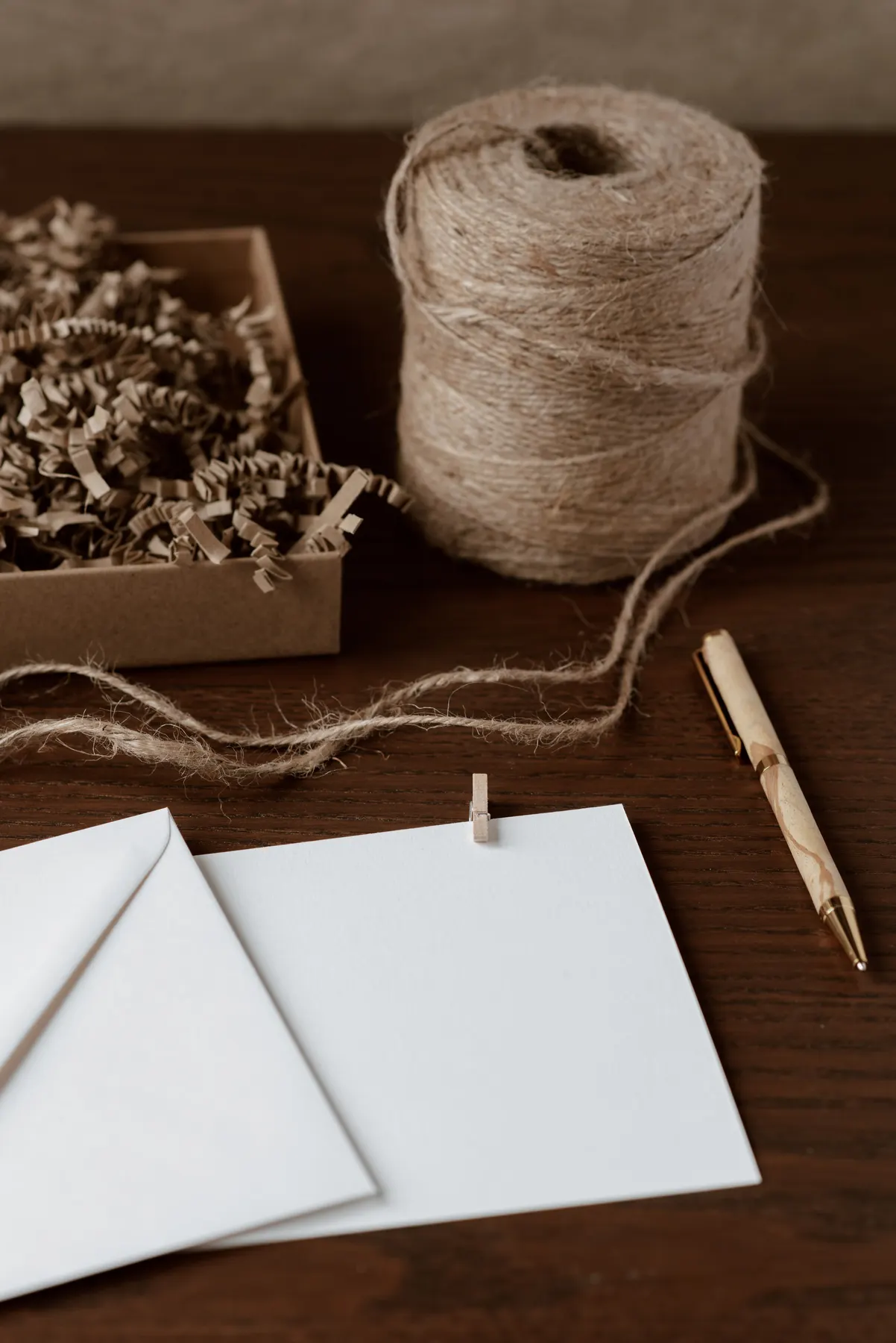 Paper, pen and twine arranged on a work surface
